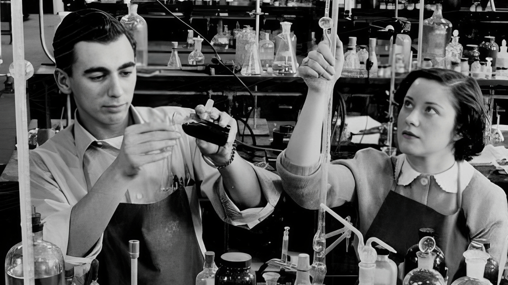 Two students work alongside each other in a chemistry lab, circa 1940s.