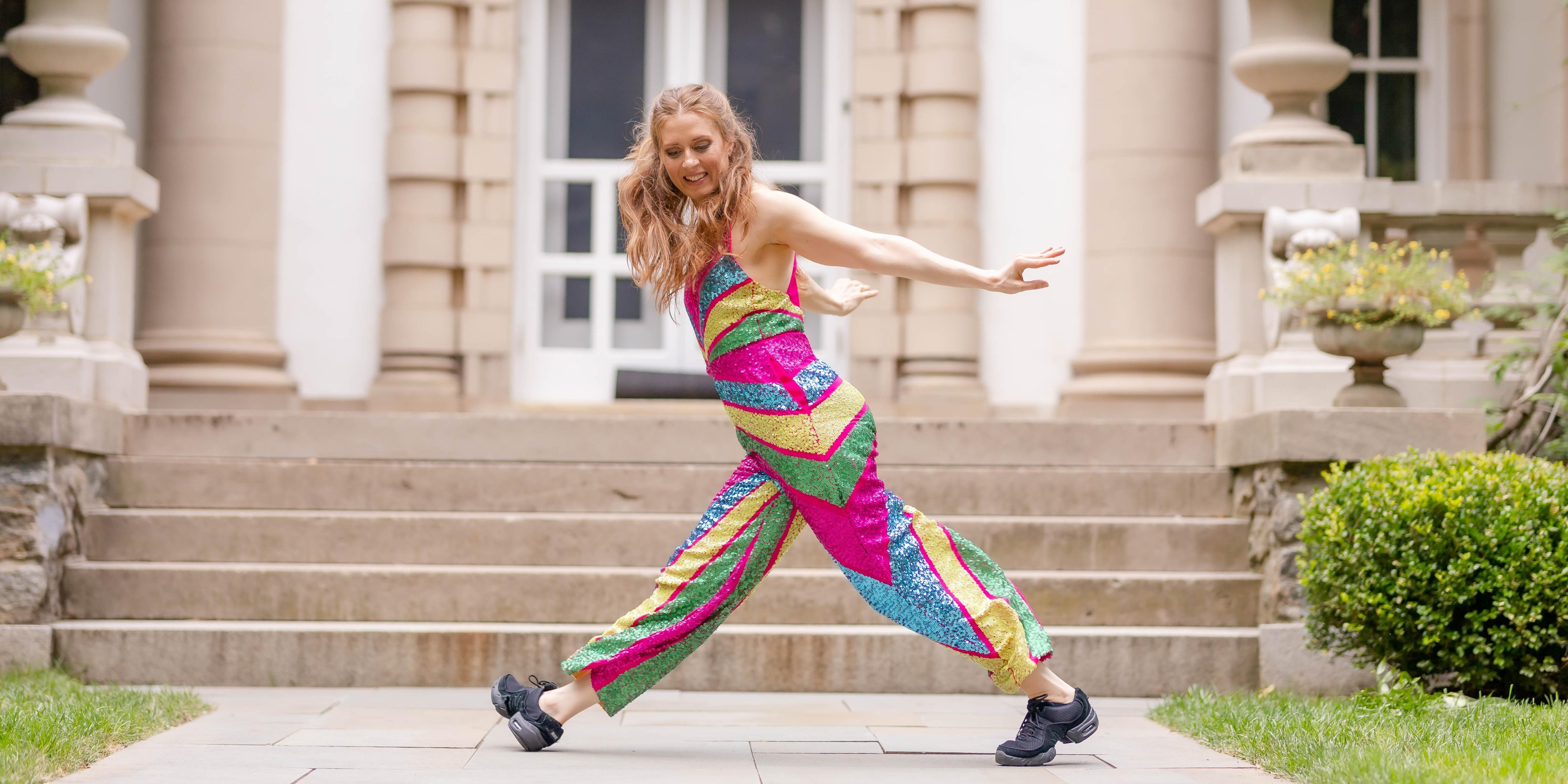 Kate Spanos dances in a sparkly, multicolored jumpsuit