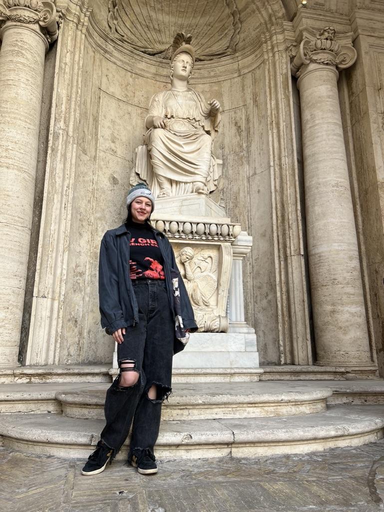 Alexys Lopez stands in front of a statue in Italy